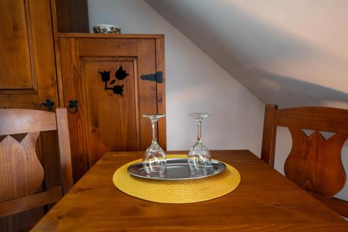 a wooden table with two glasses and a plate on it at Pensiunea Bastion - La Strada - in Sighişoara