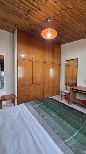 a room with a bed and a table and wooden cabinets at Mia's Home in Kalamata