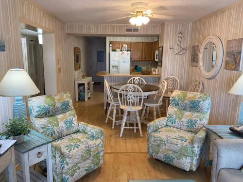 a living room with a table and chairs and a kitchen at Seasons In The Sun in North Myrtle Beach