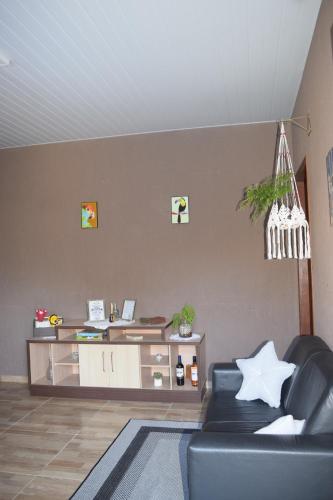 a living room with a couch and a desk at Casa Bela, perfeita para Descanso! in Morretes