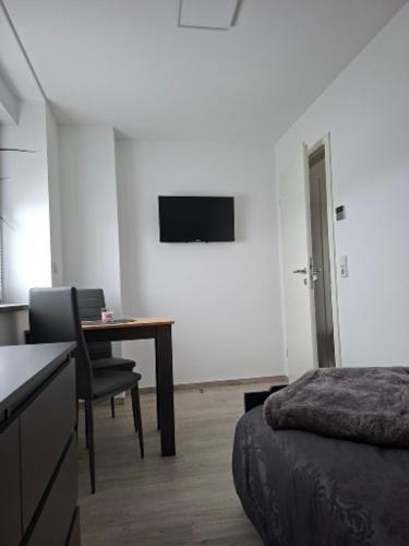 a bedroom with a desk and a bed and a table at Ferienwohnung Familie Siegl in Pouch