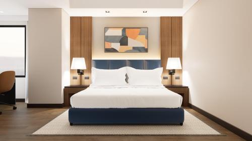 a bed in a room with two lamps and a bed sidx sidx sidx at Seda Abreeza - Newly Renovated in Davao City