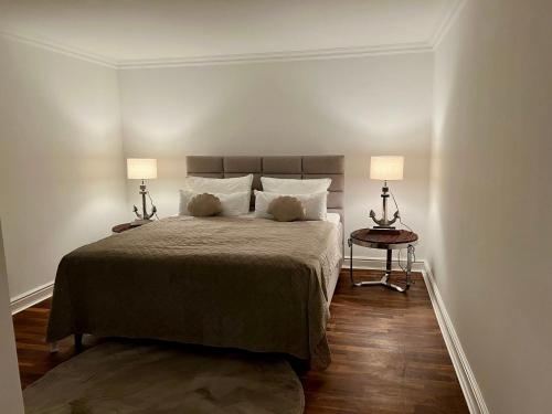 een slaapkamer met een groot bed met twee lampen bij Hygge Suite Sylt Kampen in Niederdorla