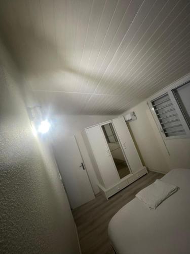 a room with a bed and a light on the ceiling at Cocon douillet entre Mer et Montagne in Basse-Terre