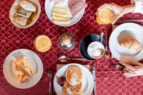 a table topped with plates of breakfast foods and coffee at La Torretta in Passo del Tonale