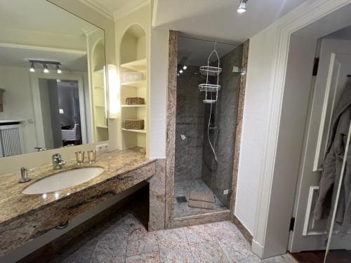 a bathroom with a sink and a shower at Hygge Suite Sylt Kampen in Niederdorla