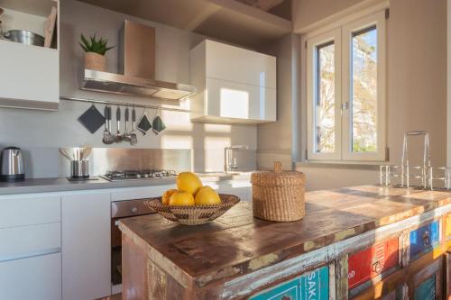 a kitchen with a bowl of fruit on a wooden counter at Sunset Terrace Loft - Best View on Como by Rent All Como in Brunate