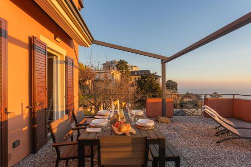 a table on the balcony of a house at Sunset Terrace Loft - Best View on Como by Rent All Como in Brunate