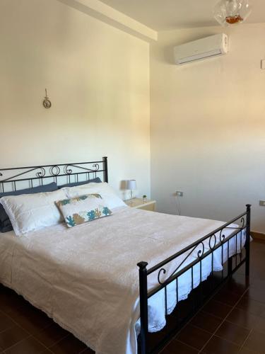 Un dormitorio con una cama con un edredón blanco. en DA BARBARINA Casa Vacanze sud Sardegna, en Capoterra