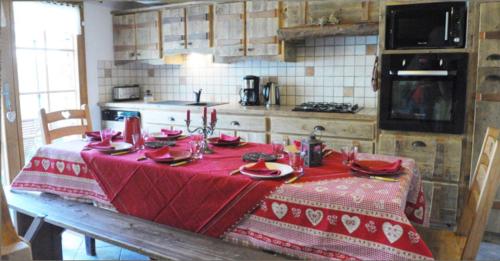 a table in a kitchen with a red table cloth at Chalet l'Angelina in Bonneval-sur-Arc