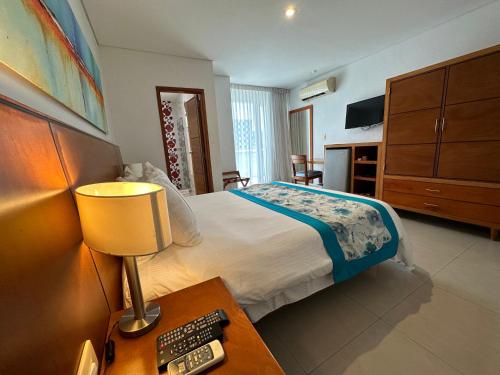 a bedroom with a bed and a table with a lamp at Hotel Atrium Plaza in Barranquilla