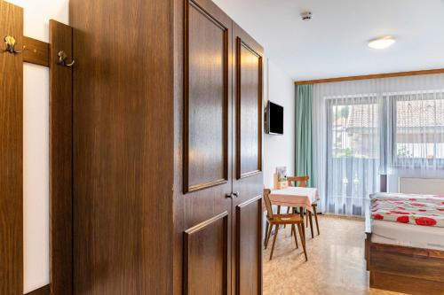 a room with a wooden door and a bedroom at Pension Heidelberg in Hopfgarten im Brixental