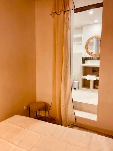 una camera da letto con un letto, una sedia e uno specchio di Citabella Bastia a Bastia
