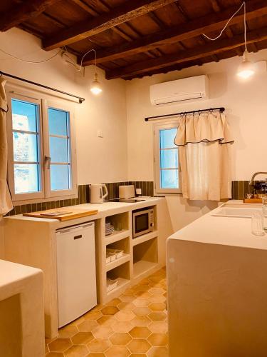 una grande cucina con ripiani bianchi e finestre di Citabella Bastia a Bastia