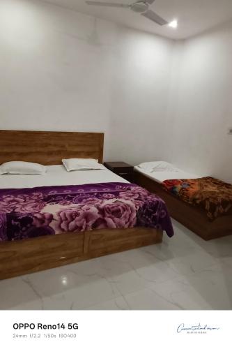 two beds in a room with purple sheets at Amit guest in in Vrindāvan