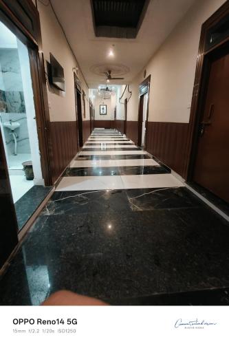 a hallway with black and white flooring in a building at Amit guest in in Vrindāvan