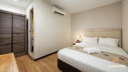 a bedroom with a large white bed in a room at Sunstone Hotel in George Town