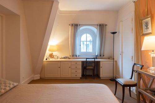 - une chambre avec un bureau et une fenêtre dans l'établissement Small haven with garden in the heart ofParis, à Paris