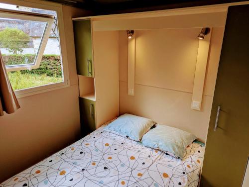 - un petit lit dans une petite chambre avec fenêtre dans l'établissement Le Chalet de la Source, à Saint-Sylvain