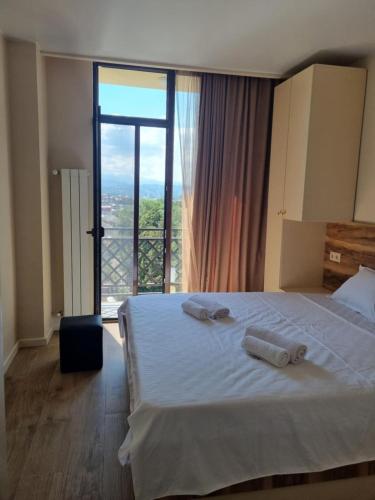 a bedroom with a bed and a large window at Montana in K'obulet'i