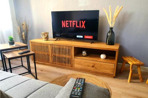 un salon avec une télévision sur un centre de divertissement en bois dans l'établissement 34 m avec wifi proche des PLAGES du Mourillon, à Toulon