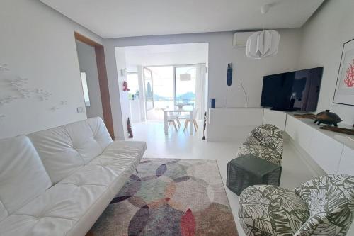 un salon avec un canapé blanc et une table dans l'établissement BRAND NEW 2 BR in Villeneuve-Loubet sea view terrasse & parking - BENAKEY, à Villeneuve-Loubet