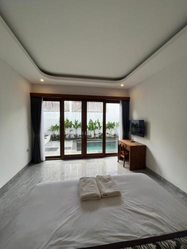 a bedroom with a bed and a desk and a window at Honeymoon Villa near Canggu in Badung