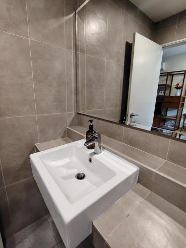 a bathroom with a white sink and a mirror at Timurbay Seafront By Moonlight in Kuantan