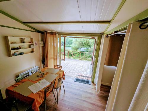 Cette chambre comprend une table et une porte donnant sur une cour. dans l'établissement Le Chalet de la Source, à Saint-Sylvain