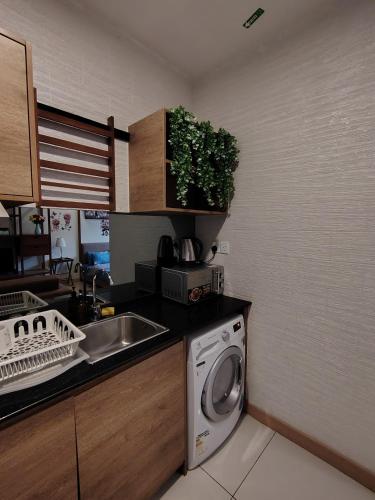 a kitchen with a washing machine and a sink at Timurbay Seafront By Moonlight in Kuantan