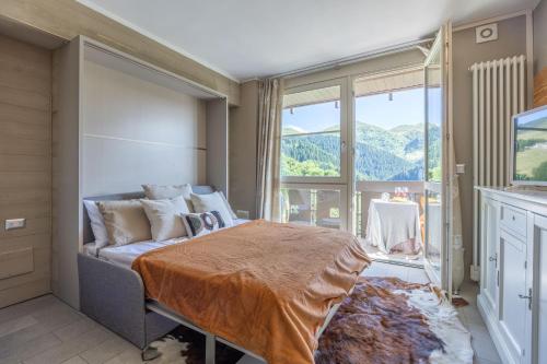 a bedroom with a bed and a large window at Prato Nevoso - Macalù Ski Apartment - GrandMaison in Prato Nevoso