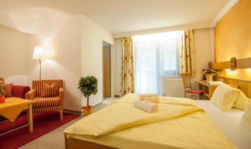 a hotel room with a bed and a chair at Hotel-Restaurant Burgblick in Dorfgastein
