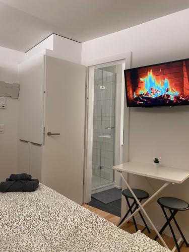 a bedroom with a bed and a television on the wall at City Studio 2 in Zürich
