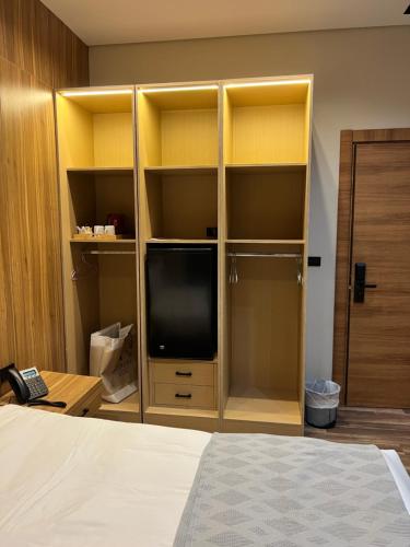 a bedroom with a tv in a cabinet with a bed at Farida Habu Palace Hotel luxor in Al Aqālitah