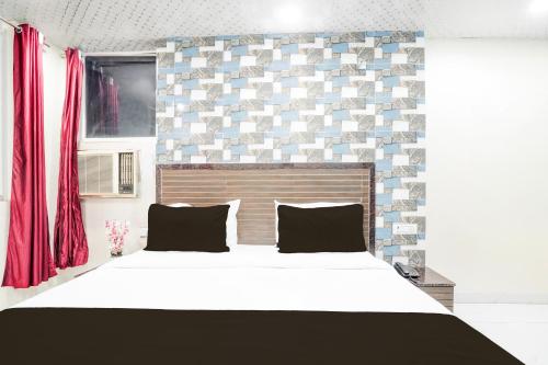 a bedroom with a large bed and a brick wall at Hotel O Pragati in Jairāmpura