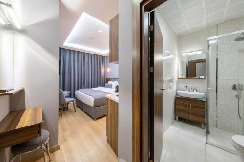 a hotel room with a bathroom and a bedroom at Beyzas Hotels & Suites in Istanbul
