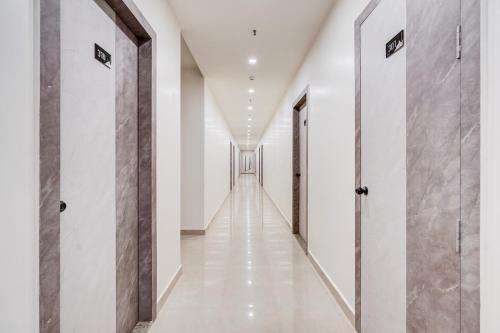 a hallway with white walls and a row of doors at Hotel O Shagun hotel and Banquets in Gomti Nagar