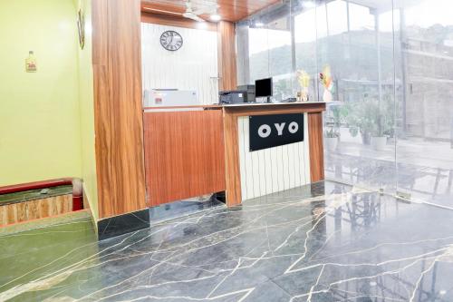 an office with a counter with an ovo sign on it at Hotel O Pragati in Jairāmpura