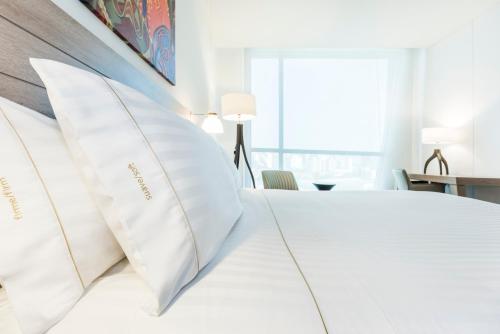a bedroom with a white bed with white pillows at Holiday Inn Express - Barranquilla Buenavista by IHG in Barranquilla
