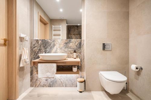 a bathroom with a sink and a toilet at Forest & Waves - Luxury Seaside Retreat with Pool, 90m to the Beach & Pro Workstations in Łukęcin