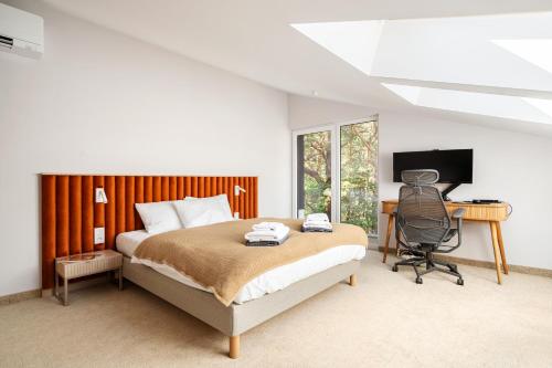 a bedroom with a bed and a desk and a computer at Forest & Waves - Luxury Seaside Retreat with Pool, 90m to the Beach & Pro Workstations in Łukęcin