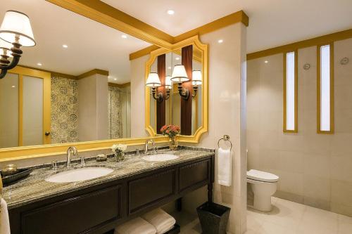 a bathroom with two sinks and a large mirror at The Grand Luang Prabang, Affiliated by Meliá in Luang Prabang