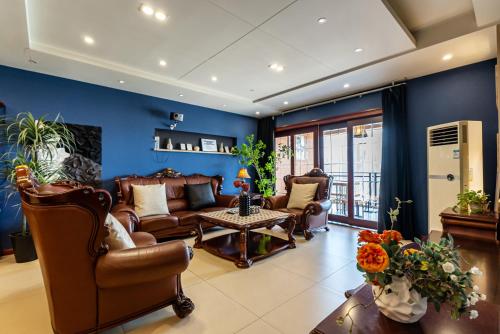 a living room with leather furniture and blue walls at Misty Nest High Altitude River View B&B Hongyadong Branch in Chongqing