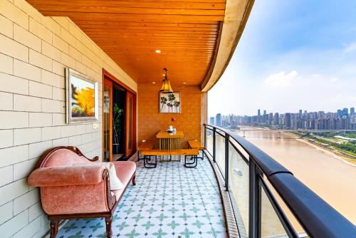 a balcony with a chair and a table on a building at Misty Nest High Altitude River View B&B Hongyadong Branch in Chongqing
