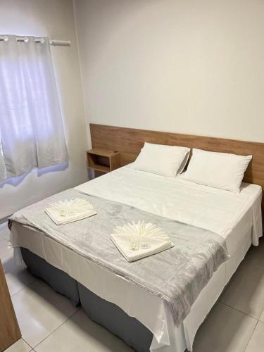 a bedroom with a bed with two napkins on it at Mahle Hotel Jataí in Jataí