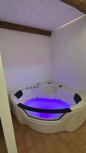 a large white bath tub with a blue dye in a room at Palazzo Ammicc in Bernalda