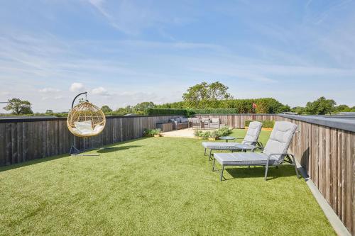 a backyard with two chairs and a hanging swing at Host & Stay - Dalby Lodge in Pickering