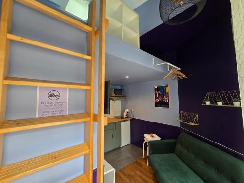 - un salon avec un canapé vert et un escalier dans l'établissement 1D- Studio tout équipé 10mins de Paris Expo porte de Versailles, à Issy-les-Moulineaux