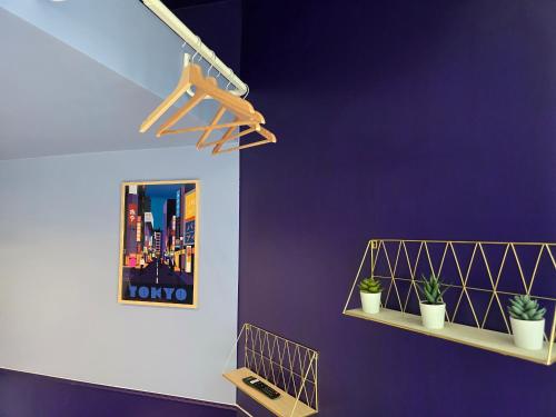 Una habitación con paredes moradas y dos estantes con plantas. en 1D- Studio tout équipé 10mins de Paris Expo porte de Versailles, en Issy-les-Moulineaux