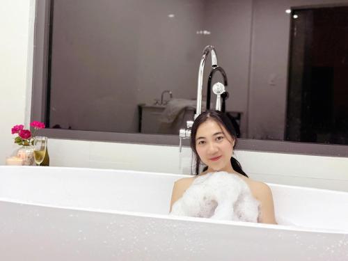 a woman is sitting in a bath tub at Katie's homestay in Ðông Mỹ (2)